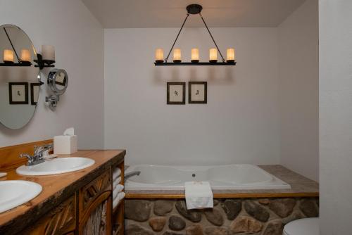 uma casa de banho com 2 lavatórios e uma banheira em The Lodge at Moosehead Lake em Greenville
