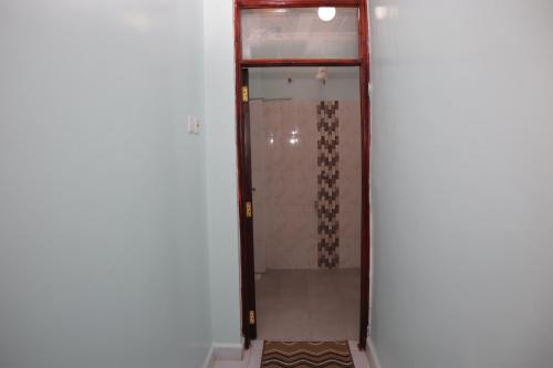 a shower with a glass door in a room at SpringStone executive suite Rm 18 in Langata Rongai