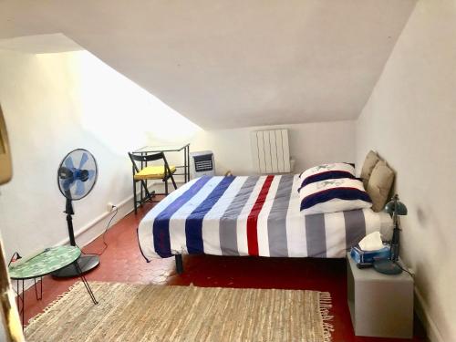 1 dormitorio con 1 cama con manta a rayas en Apt 2-3 pces dans le Carre d Or a 290 m des plages en Niza