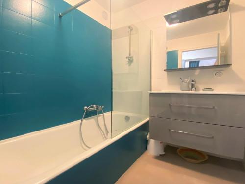 a bathroom with a tub and a sink and a mirror at Appartement rénové avec mezzanine et balcon au cœur de Samoëns, idéal pour famille nombreuse - FR-1-624-69 in Samoëns