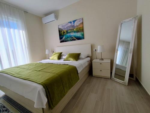 a bedroom with a large bed and a mirror at Luxury Apartment Pape in Baška Voda