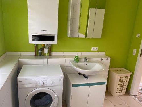uma casa de banho verde com uma máquina de lavar roupa e um lavatório em Ferienwohnung Franz Jäger Berlin em Gützkow