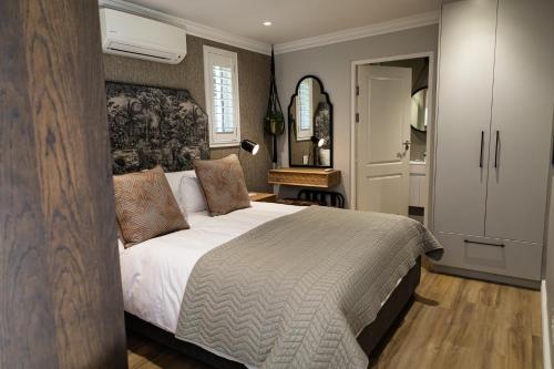 a bedroom with a large bed and a closet at Cape Village Lodge in Durbanville
