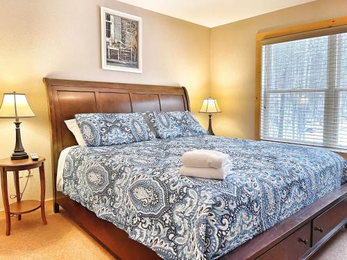 a bedroom with a bed with a blue and white bedspread at Cascade Mountain Chalet in Wilmington