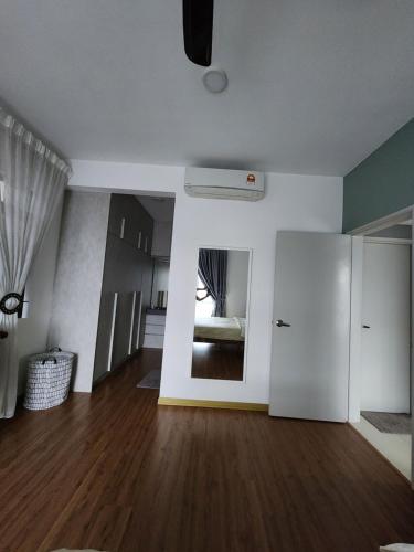 an empty living room with a bed and a white door at Little Sofia's Cottage in Kajang