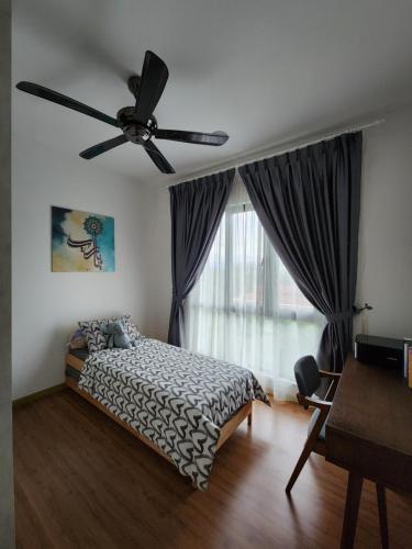 a bedroom with a bed and a ceiling fan at Little Sofia's Cottage in Kajang