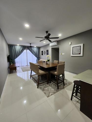 a dining room and living room with a table and chairs at Little Sofia's Cottage in Kajang