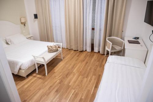 a bedroom with a bed and a table and chairs at Grand Hotel Duomo in Pisa