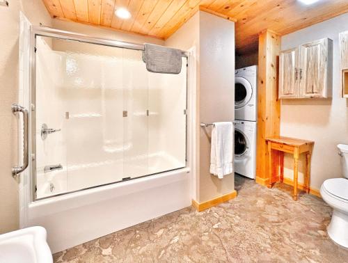 a bathroom with a shower and a washer and dryer at Cascade Mountain Chalet in Wilmington