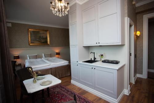 1 dormitorio con 1 cama, lavamanos y mesa en Hotell Blanka- Lägenhet- Boutique Hotell, en Varberg