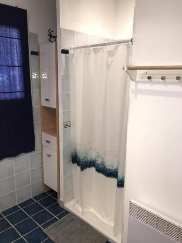 La salle de bains est pourvue d'une douche avec rideau de douche blanc. dans l'établissement Gite hameau de pomples, à Cabasse