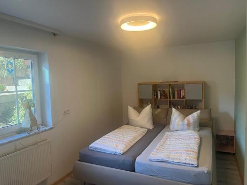 1 dormitorio con cama con almohadas y ventana en Angelina, en Baiersbronn