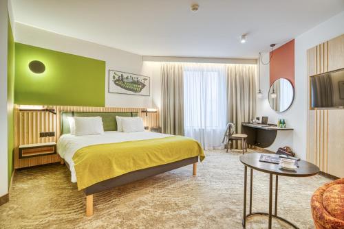 a bedroom with a bed and a green wall at Mercure Katowice Centrum in Katowice
