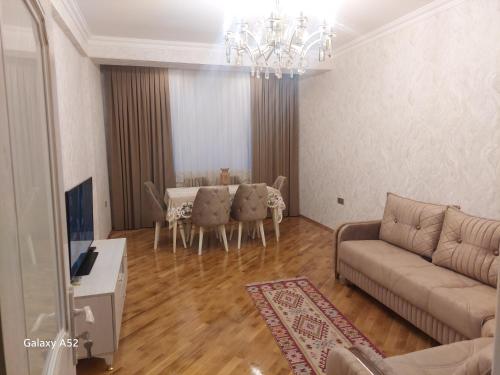 uma sala de estar com um sofá e uma mesa em Luxury Guest House em Sumqayıt