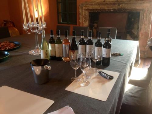 un tavolo con bottiglie di vino e bicchieri di vino sopra di Casa di Susa a San Giuliano
