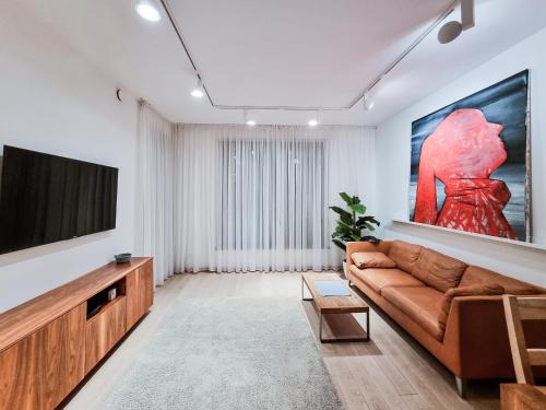 a living room with a couch and a flat screen tv at Apartament Villa Łyna Park in Olsztyn