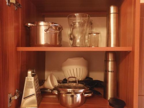 a kitchen shelf with pots and pans on it at Apartmán Susice in Sušice