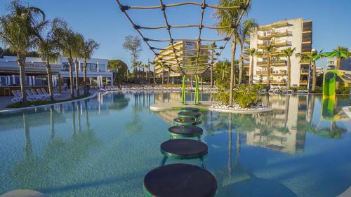 a swimming pool with chairs and a water slide at Alannia Salou in Salou