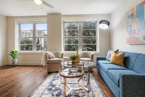 ニューオーリンズにあるModern & Fully Furnished Apartments in the Heart of the Cityのリビングルーム(青いソファ、テーブル付)