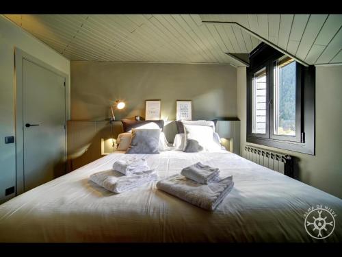 a bedroom with a large bed with towels on it at SAFORCADA de Alma de Nieve in Naut Aran