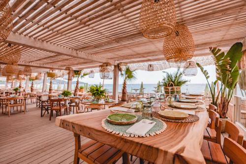 een lange houten tafel in een restaurant met tafels en stoelen bij Kon Tiki in Saint-Tropez