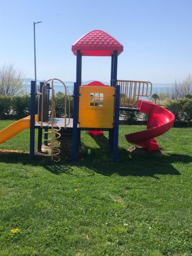 a playground with two slides on a grass field at apartment DIAMOND SARAFOVO in Burgas