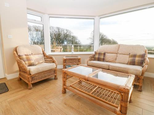 a living room with two chairs and a coffee table at Ty Top in Llanfaethlu