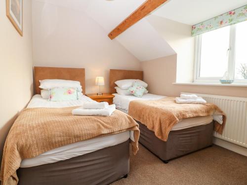 a bedroom with two beds and a window at Ty Top in Llanfaethlu