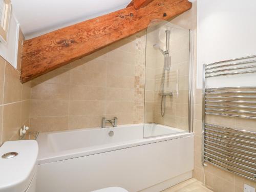 a bathroom with a tub and a toilet and a shower at Ty Top in Llanfaethlu
