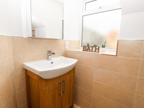 a bathroom with a sink and a mirror at Ty Top in Llanfaethlu