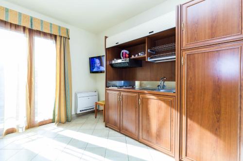 una cocina con fregadero y un gran armario de madera en Regina Elena Apartments en Olbia