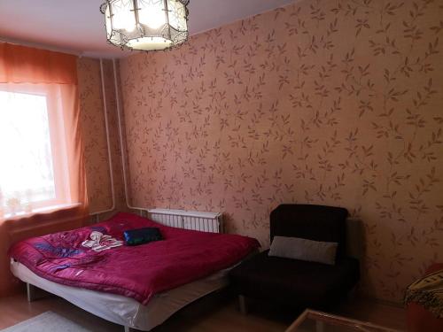 a small bedroom with a bed and a chair at Vieno kambario butas su balkonu in Kaunas