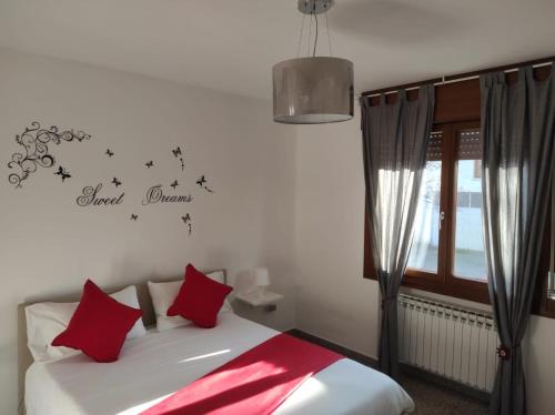 a bedroom with a bed with red pillows and a window at Red Tower Venice - 2 mins from VCE Airport- free Wifi in Tessera