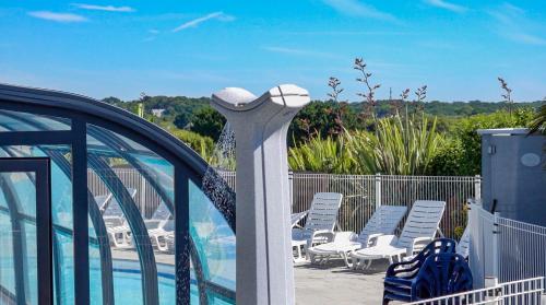 a balcony with chairs and a swimming pool at Camping le Dolmen, Carnac, Morbihan in Carnac