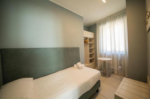 1 dormitorio con cama y pared verde en Lei Rooms, en Maranello