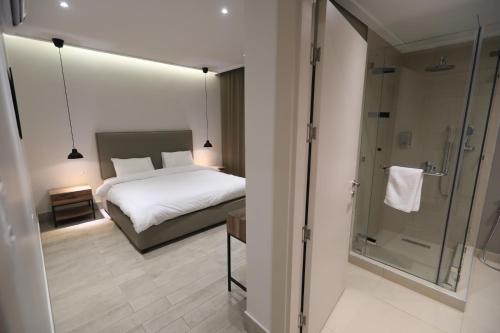 a bedroom with a bed and a glass shower at Zerø Føur DeadSea in Sowayma