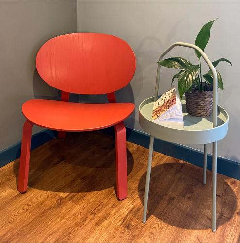 a red chair next to a table with a plant at Masonic Arms Gatehouse in Gatehouse of Fleet