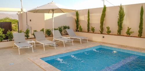 a patio with chairs and a swimming pool at Zerø Føur DeadSea in Sowayma