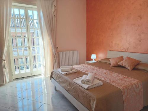 a bedroom with a bed and a large window at CasaEtnaMarty Acireale in Acireale