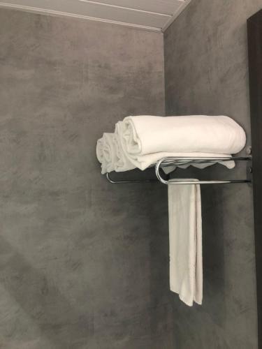 a towel rack in a bathroom with white towels at Apart-Hotel de Luxo em Lourdes in Belo Horizonte