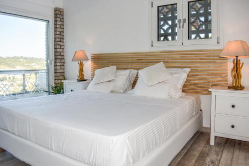 a bedroom with a large white bed with white pillows at View Villa in Skiathos Town