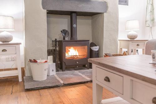 a fireplace in a living room with a stove at Bend or Bump Coniston in Coniston