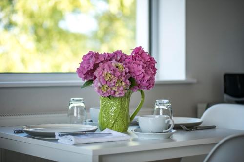 un vase rempli de fleurs violettes assises sur une table dans l'établissement Stibb Hollow Farm, à Great Torrington