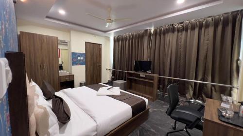 a bedroom with a bed and a desk and a chair at UR Residency New BEL ROAD in Bangalore