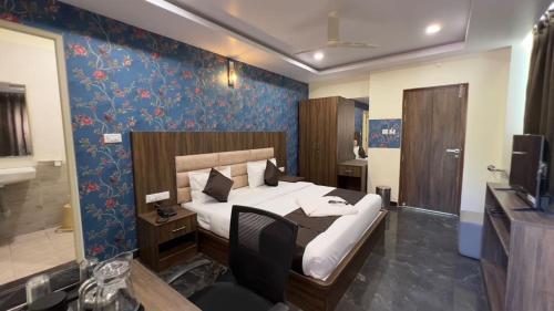 a bedroom with a bed and a desk and a television at UR Residency New BEL ROAD in Bangalore