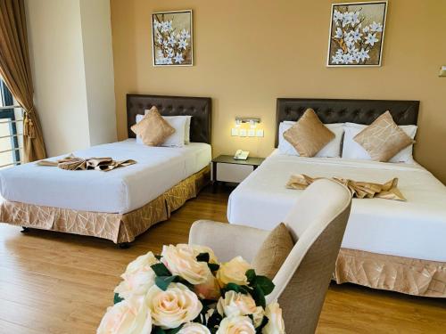 a hotel room with two beds and a couch at Wafa Hotel & Apartment in Kampong Mata Mata