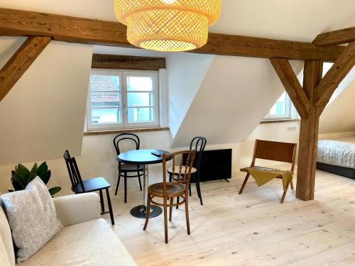 a living room with a table and chairs and a bed at kleines Stadthaus in Isny im Allgäu