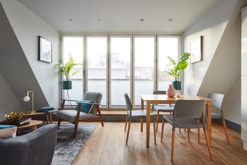 a living room with a table and chairs at Holborn by Viridian Apartments in London