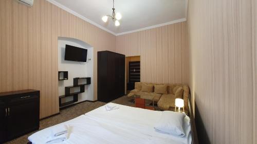 a hotel room with a bed and a couch at Apart-Hotel City Center Contrabas in Lviv