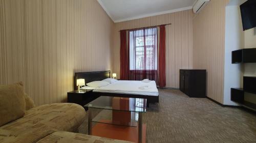 a hotel room with a bed and a couch at Apart-Hotel City Center Contrabas in Lviv